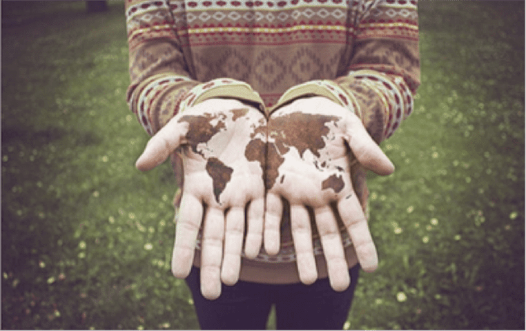 Mãos abertas com o mapa mundi desenhado.