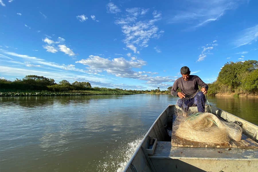 Imagem de pescador em barco no Rio Grande