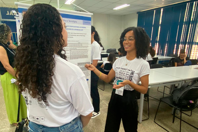 Foto de estudante de iniciação científica em exposição de pôsteres da UFOB