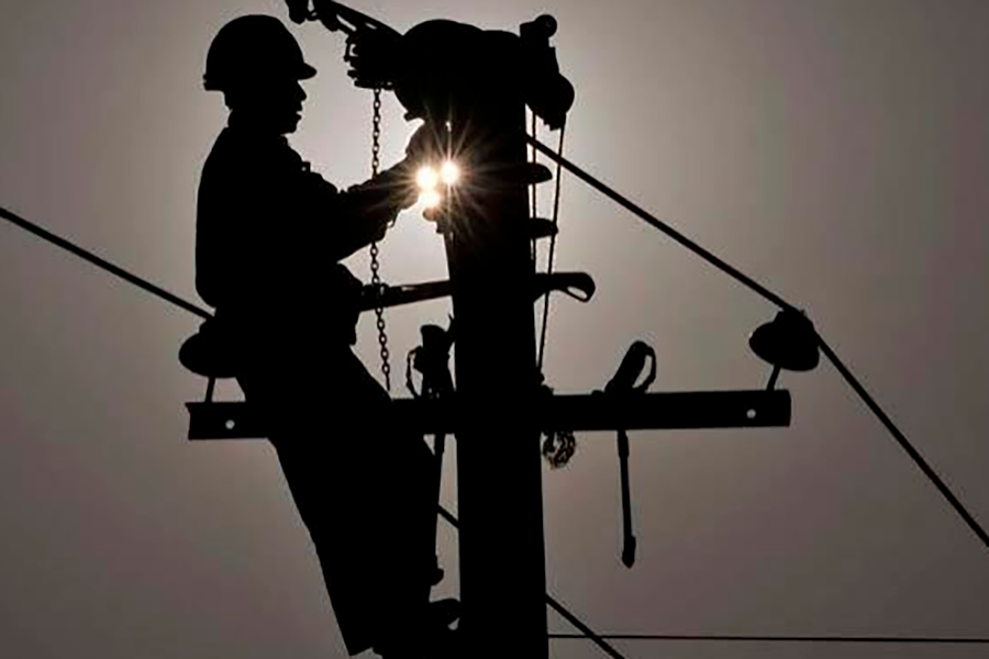 Imagem de homem trabalhando na manutenção de rede elétrica em poste