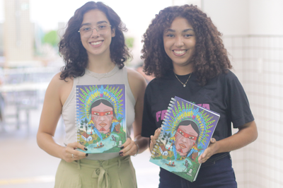 Imagem de estudantes de gradauação retirando o novo caderno institucional da UFOB