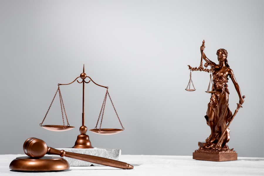 Imagem com símbolo da balança da justiça, malhete e estátua com balança da justiça