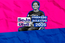 Arte em fundo rosa e azul com foto de estudante cadeirante e texto " Seja UFOB# Processo Seletivo 2025"