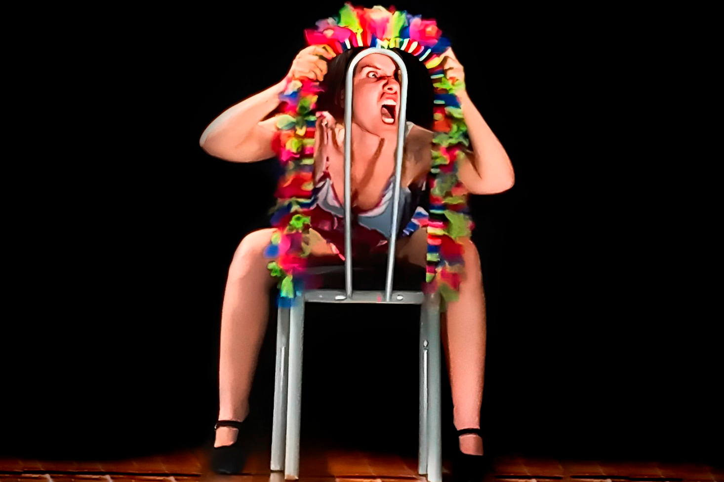 Foto de mulher sentada numa cadeira num ambiente de pouca luz 