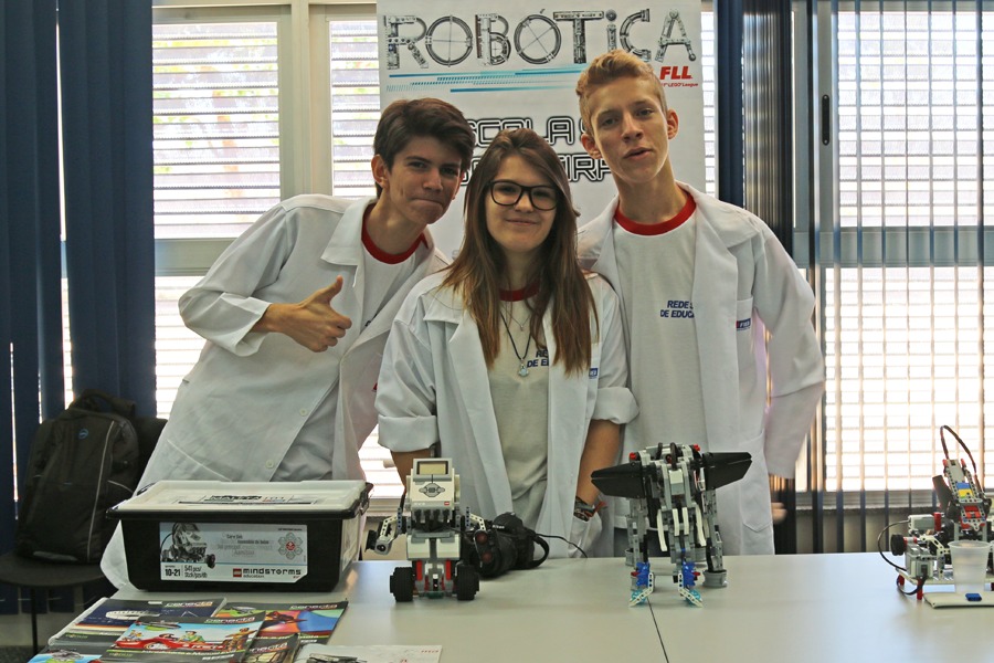 Imagem de estudantes de ensino médio posando para fotos com jaleco na Biblioteca do Campus Reitor Edgard Santos, em Barreiras