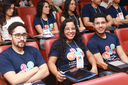 Participantes assistem a uma palestra em um auditório.