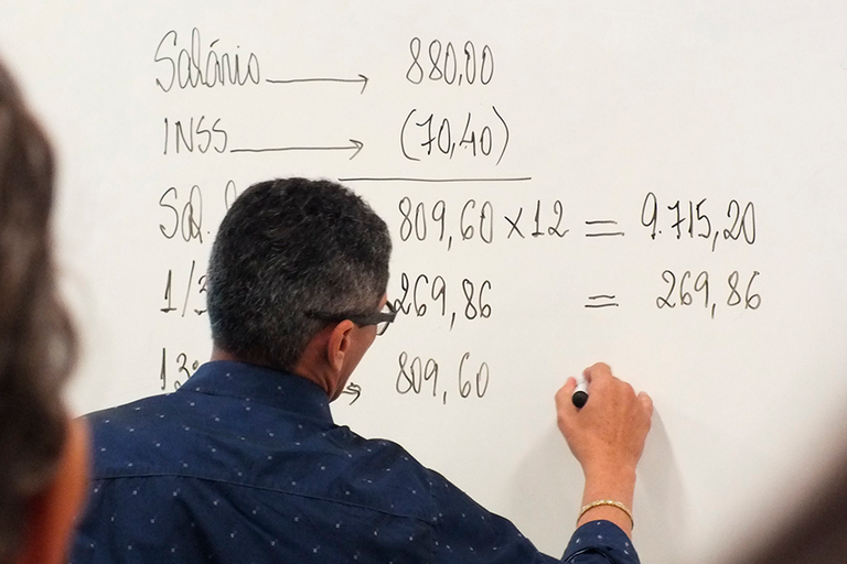 Foto de professor de matemática fazendo conta em quadro branco