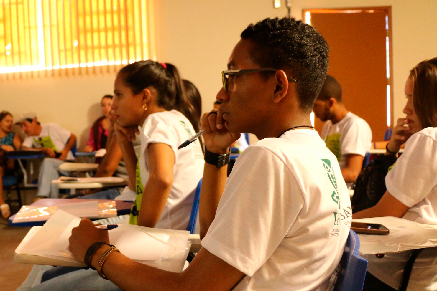 Imagem de sala de aula, com estudantes durante atividade acadêmica