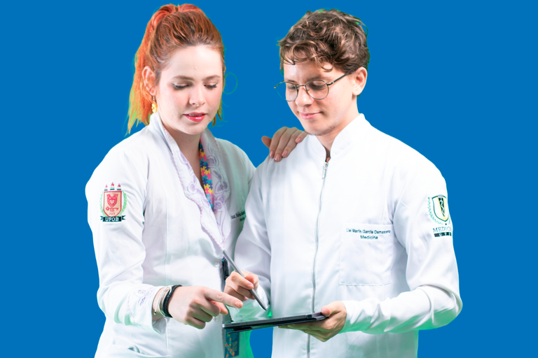 Imagem de duas pessoas estudantes de Medicina vestidos com jaleco e olhando para um prontuário