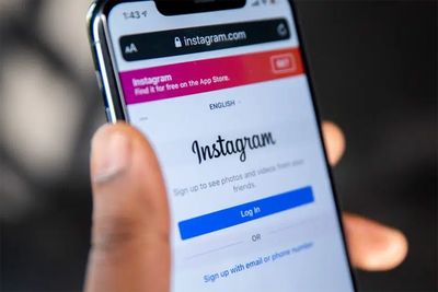 Imagem de mão segurando um smartphone logado no Instagram