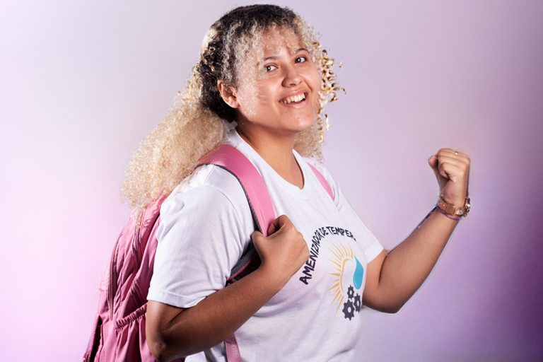 Arte em fundo degradê rosado com imagem de estudante vibrando