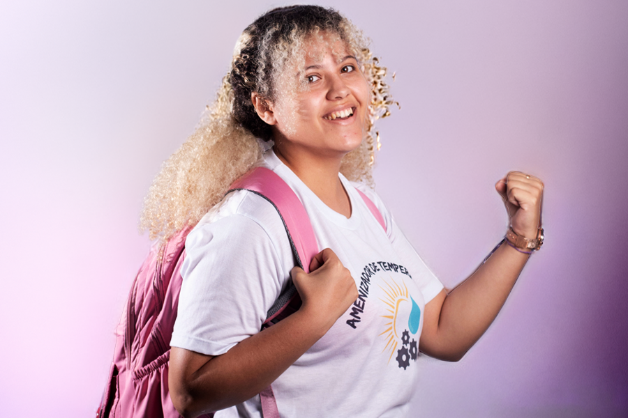 Arte em fundo degradê rosado com imagem de estudante vibrando
