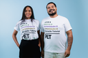 Dois jovens estudantes da UFOB. Uma mulher à esquerda e um homem à direita. Ambos vestem camisetas iguais, na cor branca, estampadas com a marca do Programa de Educação Tutorial - PET