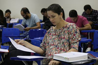 Foto de candidatos realizando prova numa sala de aula