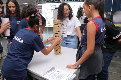 Imagem de estudantes jogando o jogo de madeira em uma mesa.