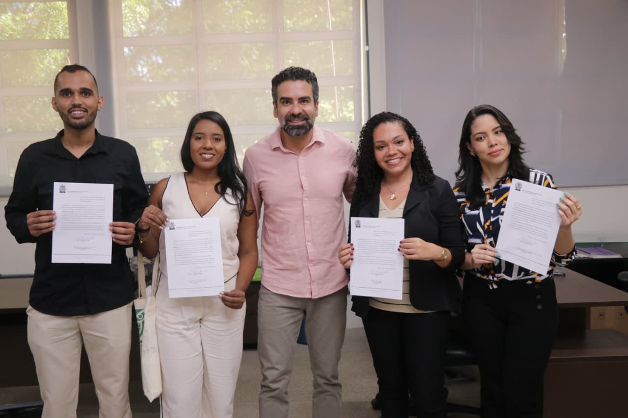 Imagem posada de quatro novos servidores e pró-reitor de Gestão de Pessoas, Clayton Barcelos, após a posse