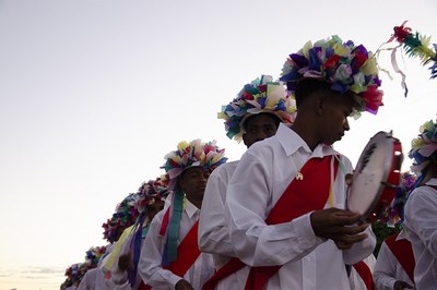 Imagem de grupo de pessoas em trajes tradicionais, tocando instrumentos
