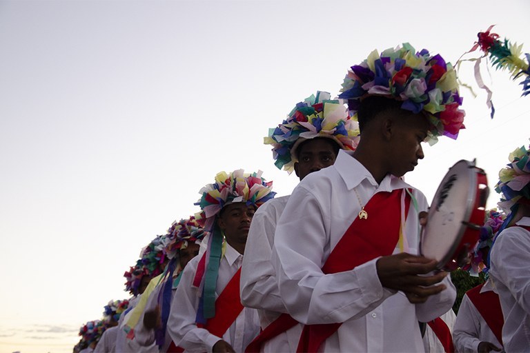 Imagem de grupo de pessoas em trajes tradicionais, tocando instrumentos