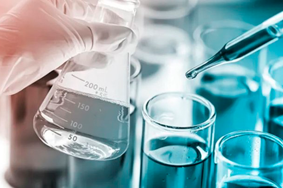 Imagem de mão de pessoa manuseando vidrarias em laboratório