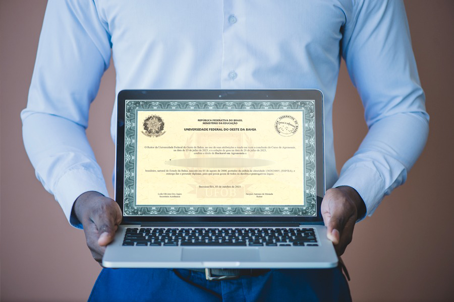 Homem segurando um computador com diploma de graduação digital