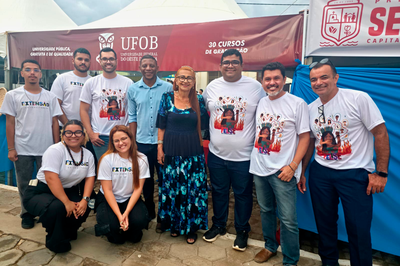 Imagem de pessoas da comitiva da UFOB posando para foto em frente ao estande da instituição na Festa Literária de Seabra