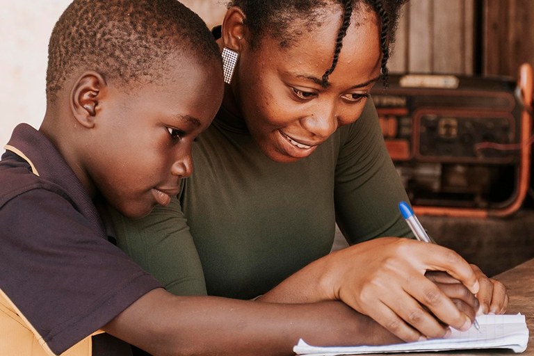 Imagem de professora e estudante negros em ambiente escolar